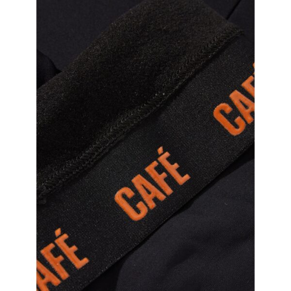 Macro detail of the brushed Italian fabric and orange Cafe du Cycliste branding on the leg gripper band