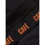 Macro detail of the brushed Italian fabric and orange Cafe du Cycliste branding on the leg gripper band