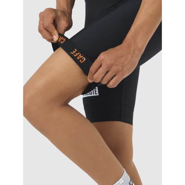 Close-up of the wide silicone-free leg gripper band on the Cafe du Cycliste Cecile bib short being lifted from the thigh