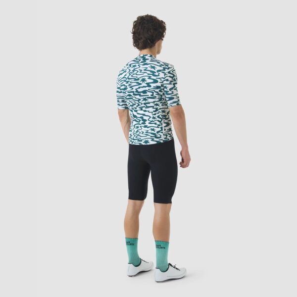 Cyclist wearing the Cafe du Cycliste Laurette jersey in Stars Dark Sea, back view showing the three rear pockets