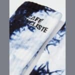 Close-up of the knitted high cuff and Cafe du Cycliste logo on the Tie Dye socks