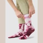 Cyclist wearing the Cafe du Cycliste Tie Dye socks in Red Moss