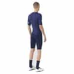 Rear view of a cyclist wearing the navy Cafe du Cycliste Vinciane jersey