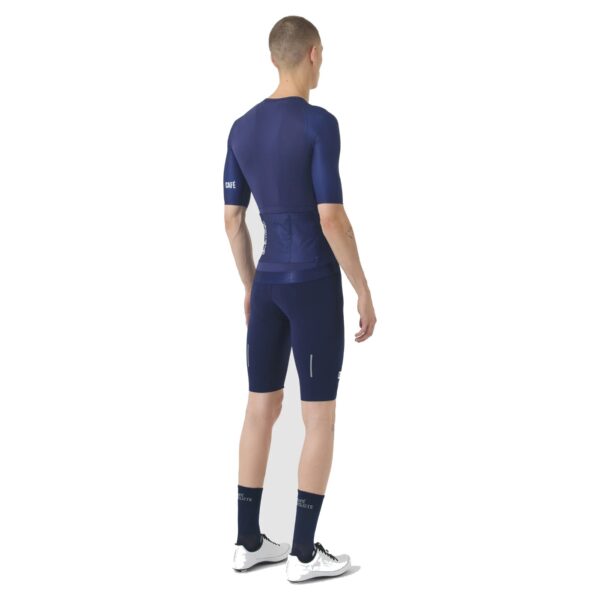 Rear view of a cyclist wearing the navy Cafe du Cycliste Vinciane jersey