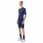 Three quarter view of a cyclist wearing the navy Cafe du Cycliste Vinciane jersey