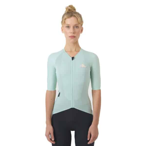 Woman wearing the jadeite Cafe du Cycliste Vinciane jersey, front view showing the close performance fit