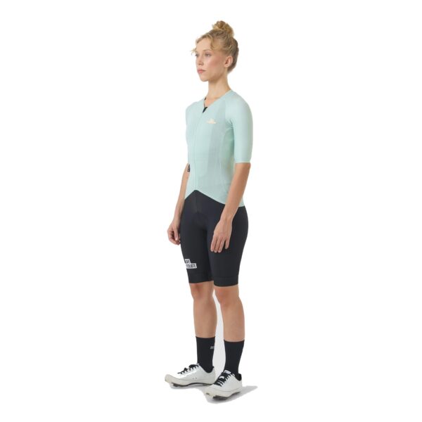 Three quarter view of a woman wearing the jadeite Cafe du Cycliste Vinciane jersey