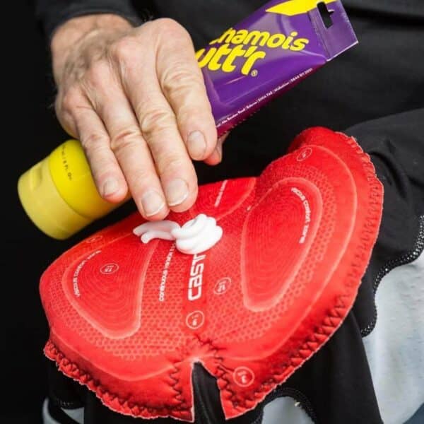 Applying Chamois Butt’r Original anti-chafe cream directly to the chamois pad of cycling bib shorts