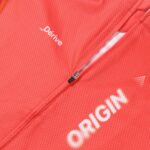 Dérive Origin jersey in _Dérive Red, close-up of the front zip, textured fabric and _Dérive logo