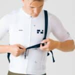 Rider adjusting the stabilising strap of the black Dérive Purposeful Musette