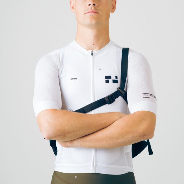 Front view of a rider wearing the Dérive Purposeful Musette cross-body with the bag on the back