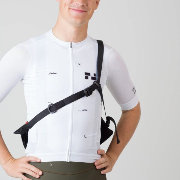 Rider wearing the black Dérive Purposeful Musette across the body with the stabilising strap over the chest
