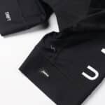 Dérive Volume bib shorts in Black, raw-edge leg with _Dérive logo tab