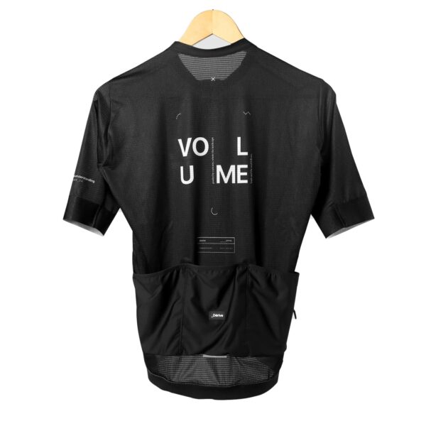 Back of the black Dérive Volume women’s cycling jersey with VOLUME print and rear pockets