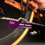 Closing a chain quick link with pliers while the Dynamic Double Checker holds the chain