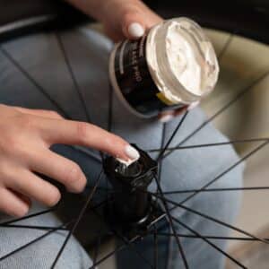 Applying Dynamic Galli Grease Pro by hand to the rear hub bearing of a road bike wheel