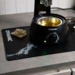Dynamic Waxifyer hot wax pot standing on the Dynamic Mat Max in a home workshop