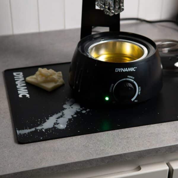 Dynamic Waxifyer hot wax pot standing on the Dynamic Mat Max in a home workshop