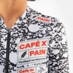 Close-up of the CAFÉ X PAIN chest print on the Angeline Pain jersey