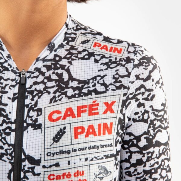 Close-up of the CAFÉ X PAIN chest print on the Angeline Pain jersey