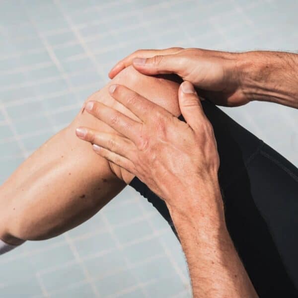 Cyclist massaging Dynamic Sunsation SPF 50 into the skin of his knee and leg