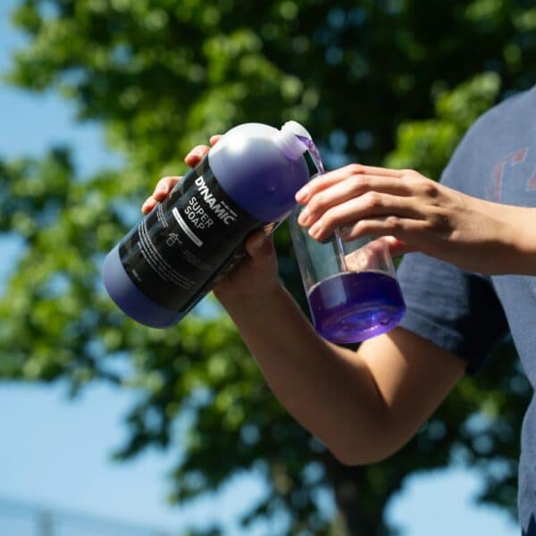 Pouring a dose of purple Dynamic Super Soap Concentrate into a foam bottle
