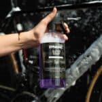 Dynamic Super Soap 1 L spray bottle held next to a foam-covered bike