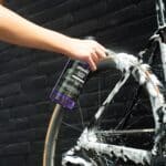 Spraying Dynamic Super Soap thick foam onto a bike wheel and frame