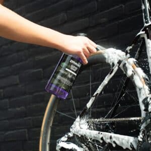 Spraying Dynamic Super Soap thick foam onto a bike wheel and frame