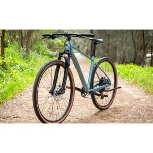 Polygon Heist 5 hybrid bike in Blue, front three-quarter view on a gravel path