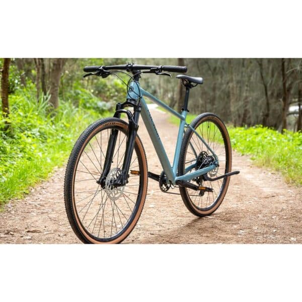 Polygon Heist 5 hybrid bike in Blue, front three-quarter view on a gravel path
