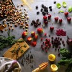 Ingredients of the Veloforte Di Bosco bar laid out on a stone surface: red berries, nuts and lemon