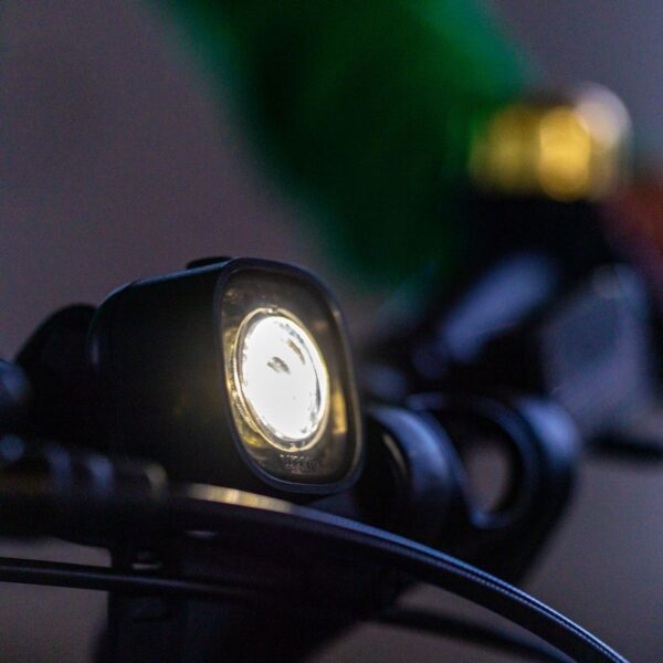 woom BEAM white front light fitted to a kids’ bike handlebar