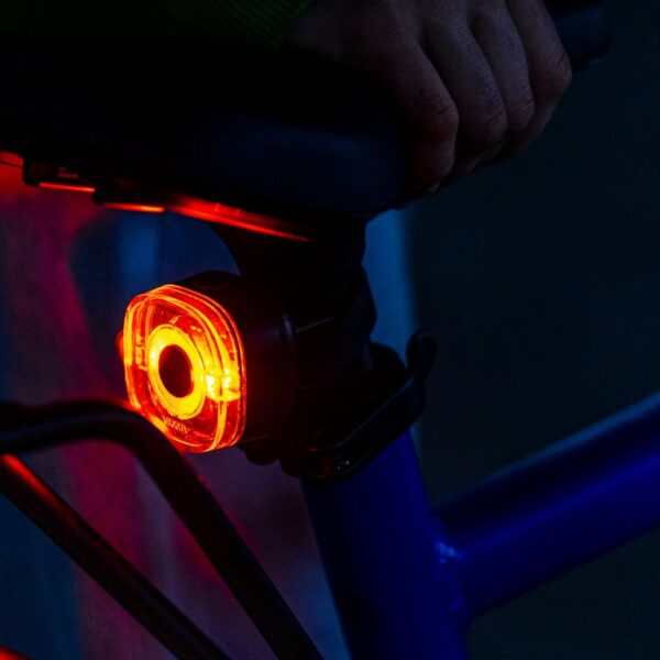 woom BEAM red rear light glowing on a kids’ bike seatpost